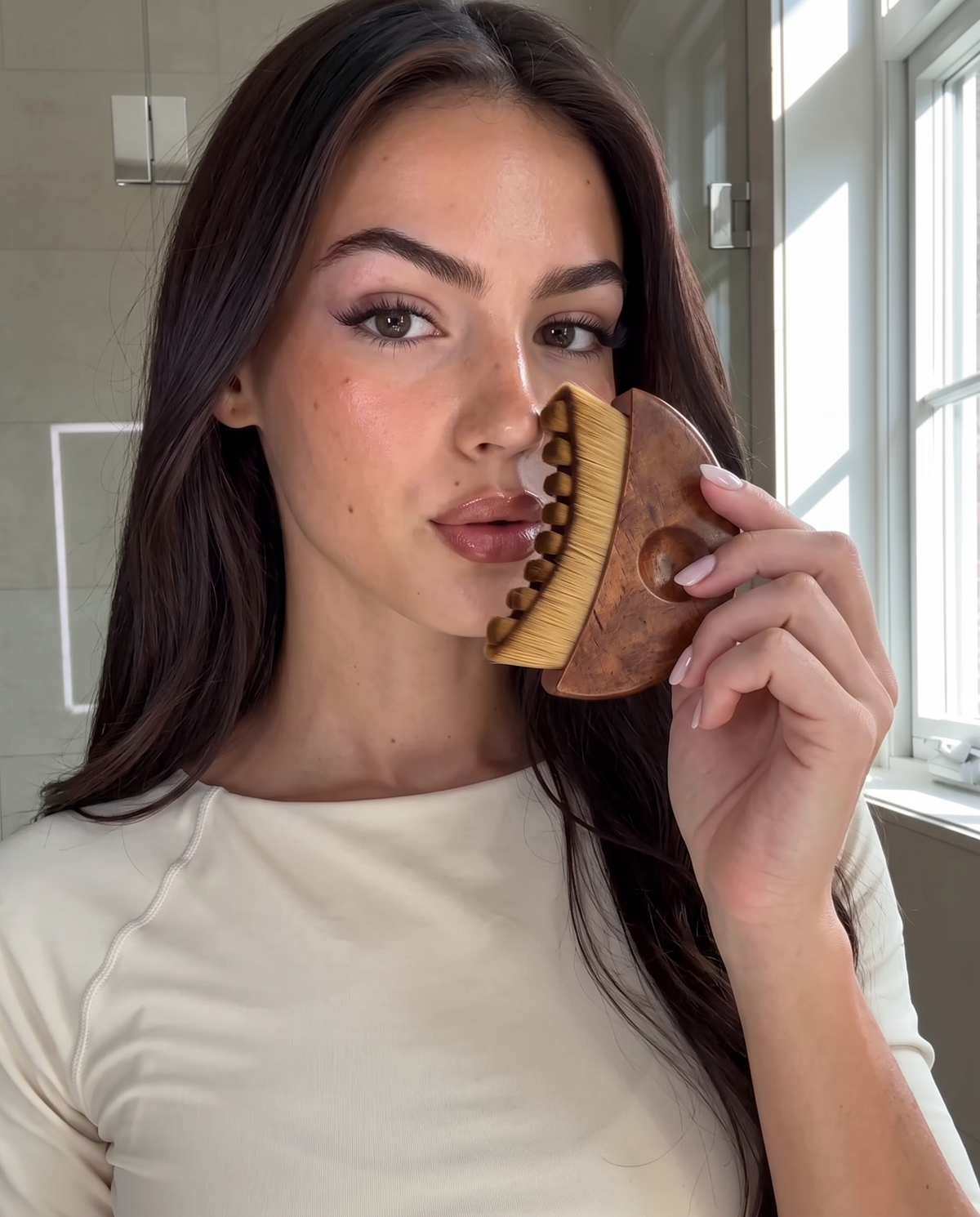Placing the Velynie facial brush beside the nose on a clean, dry face