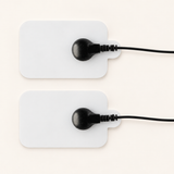 Deux électrodes EMS blanches avec leurs connecteurs et câbles noirs